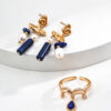 The Oracle’s Whisper Set showcases a harmonious blend of deep blue Lapis Lazuli and vintage gold, featuring the Oracle’s Echo Earrings and Seer’s Vision Ring. The set is designed to empower wearers with wisdom, enhance communication, and provide a sense of serenity, aligning perfectly with the transformative energies of 2025.