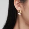 Verdant Bloom Earrings – Gold-plated monstera leaves with delicate pearl accents, inspired by nature’s beauty.